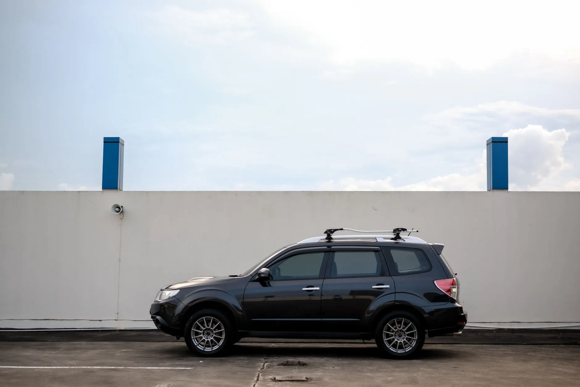 Schwarzer SUV in der Seitenansicht vor einer hellen Wand