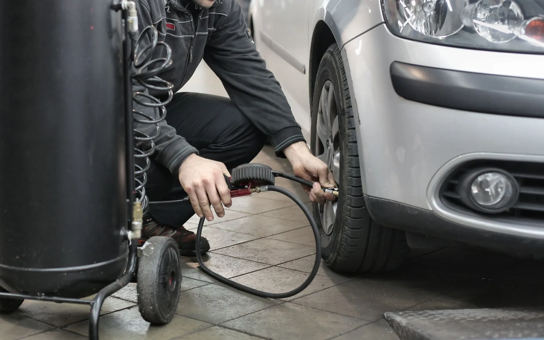 Mechaniker prüft den Reifendruck in einer Werkstatt