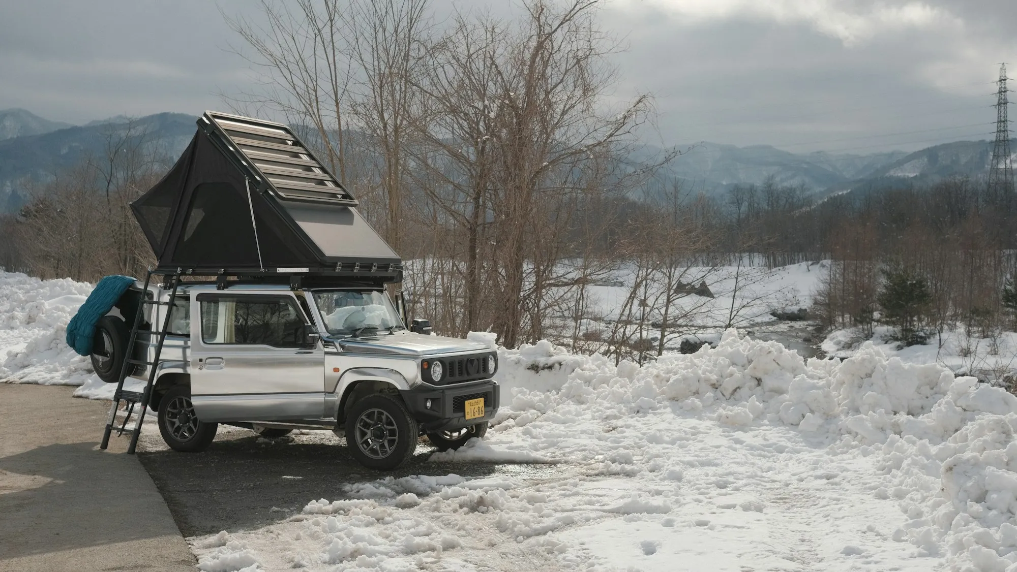 Geländewagen mit Dachzelt im Schnee